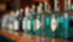 Close-up view of various gin bottles on a bar