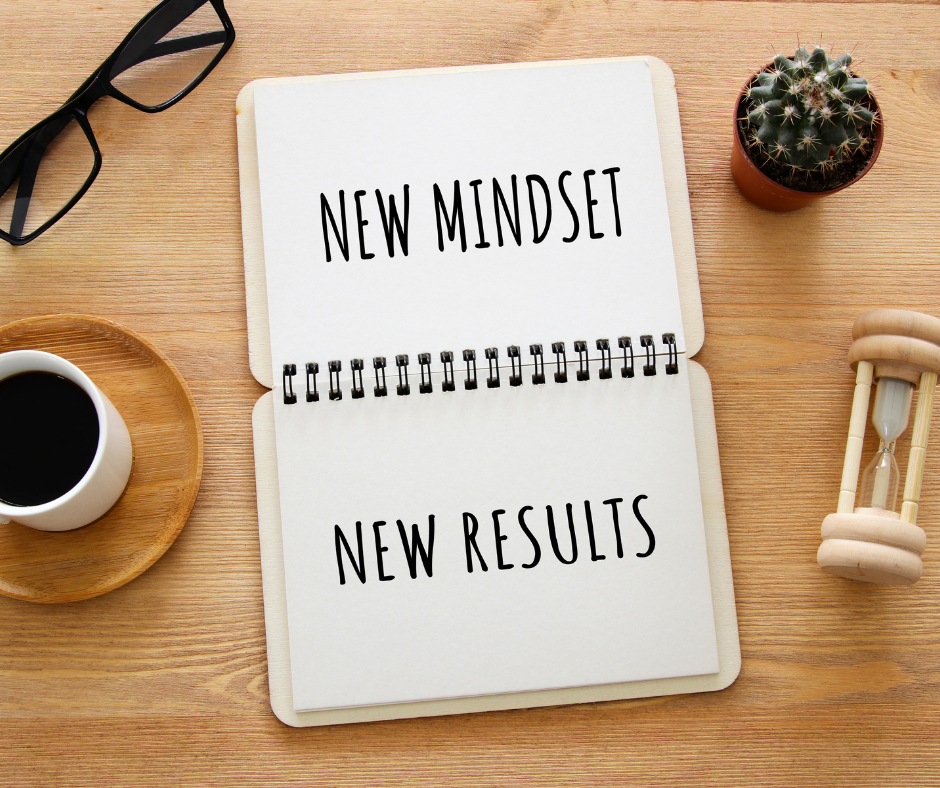 A book on a desk displaying the words "New Mindset New Results"