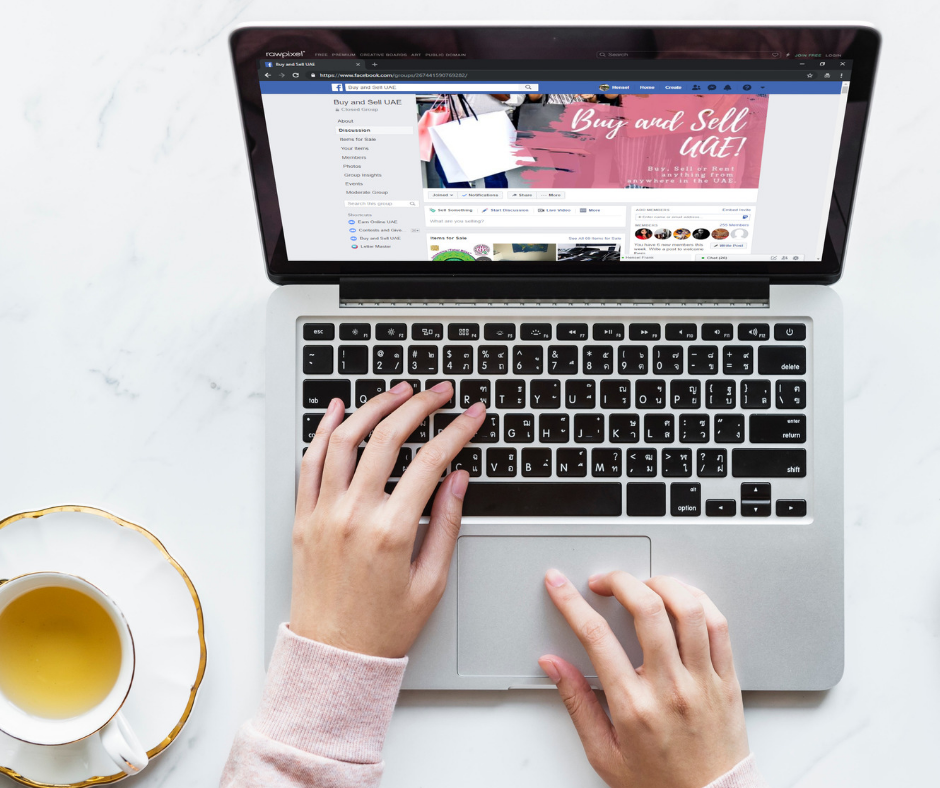A lady using her laptop to access Facebook groups on her web browser.