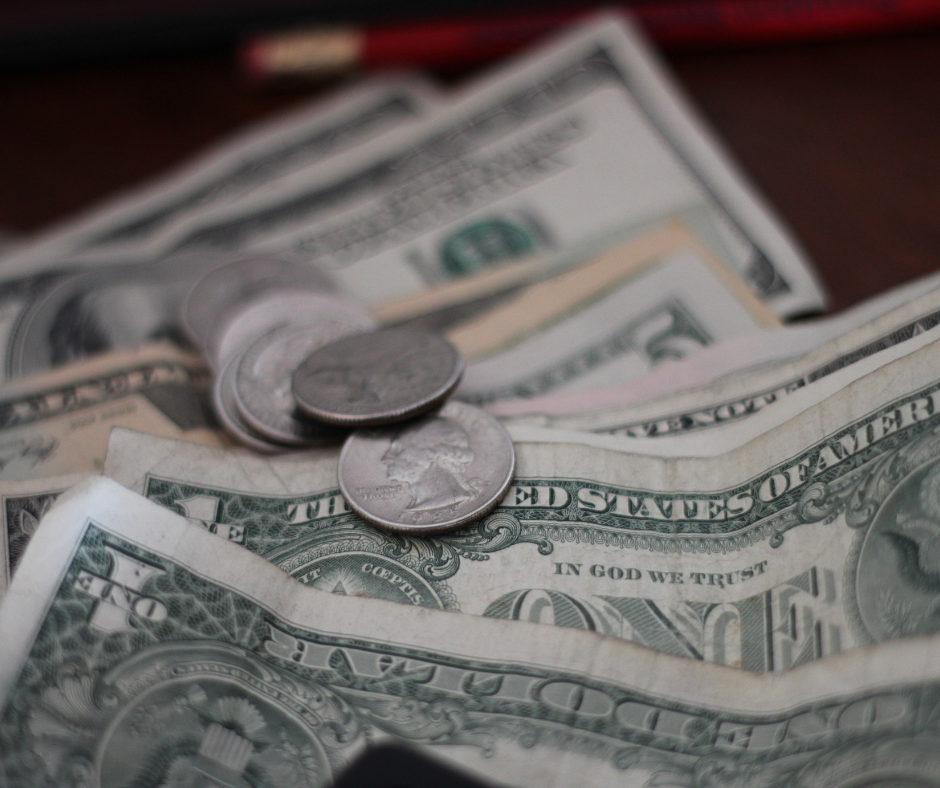 A bunch of one dollar bills and coins collected for an emergency fund.