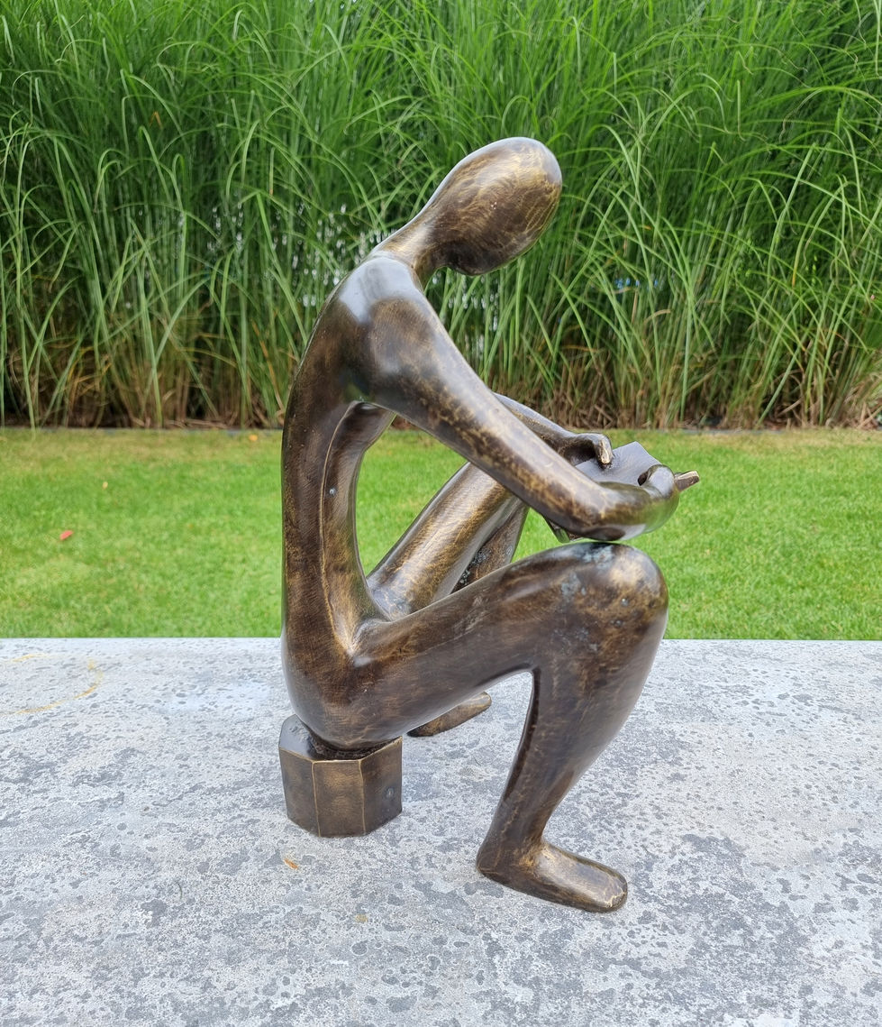 bronze sculpture of a man sitting and reading a book - abstract - modern art