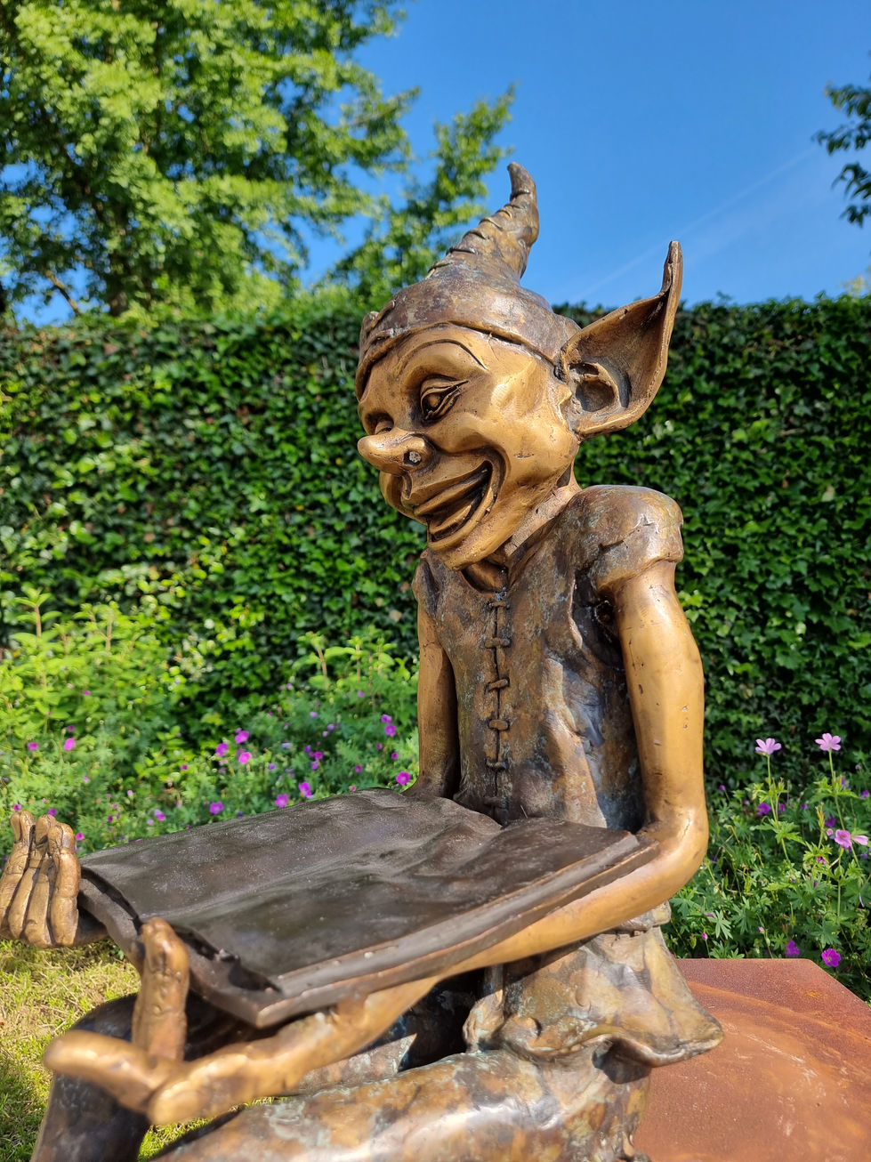 Bronze statue of a gnome reading a book - garden statues
