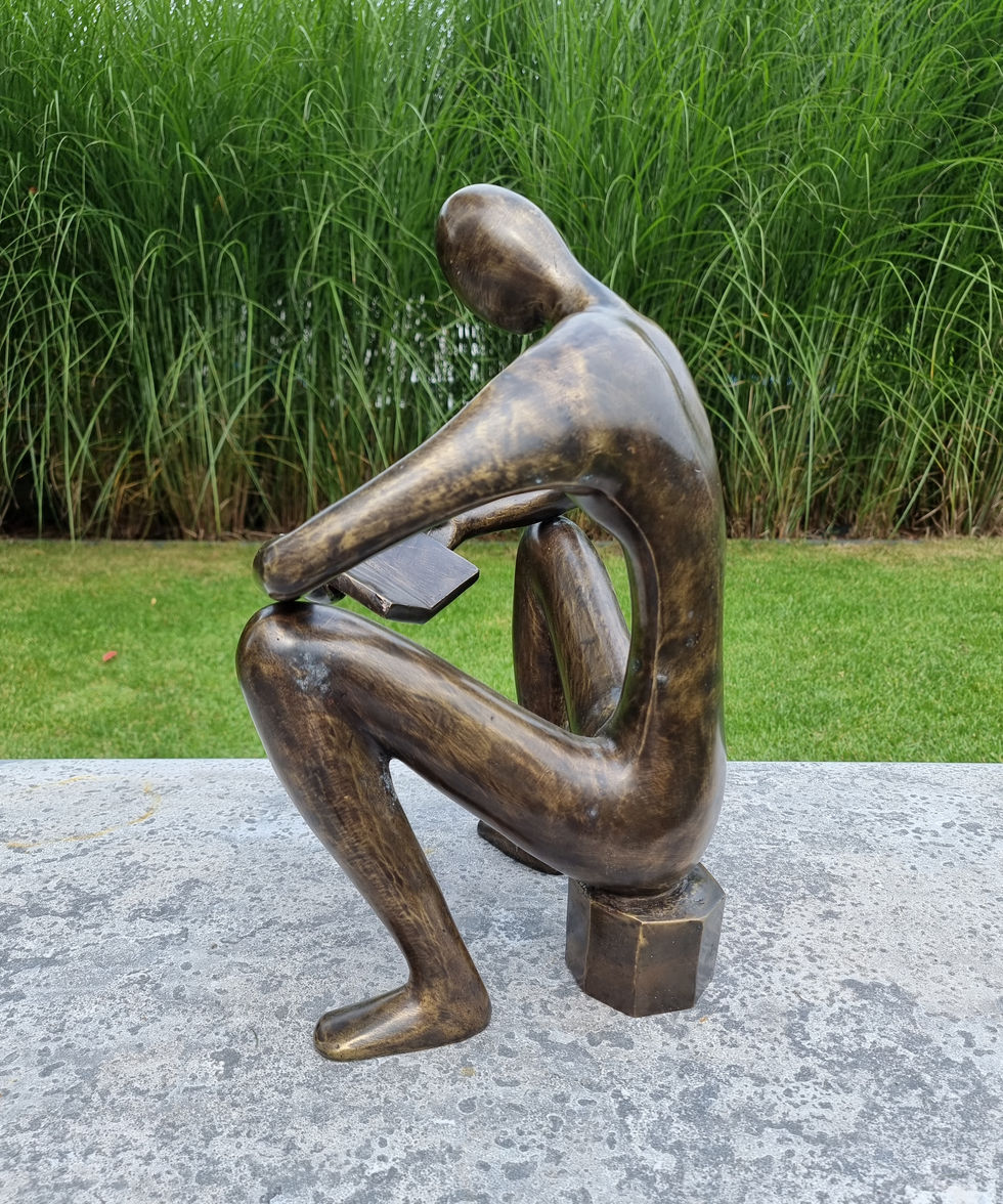 bronze sculpture of a man sitting and reading a book - abstract - modern art
