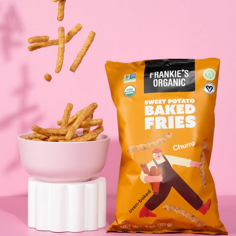 Orange bag of snacks with accompanying bowl on a pink backdrop