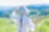 Person in white robe and hat admires scenic mountains