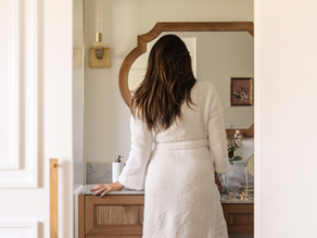 woman looking into a bathroom mirror