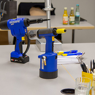 Ein Tisch mit Werkzeugen, Getränken, Stiften und Collegeblöcken.