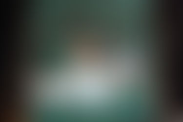 Eine grüne Holztür an der Bilder und Hufeisen hängen.