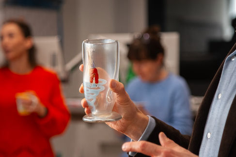 Ein bemaltes Glas in einer Hand.