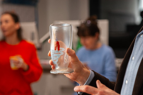 Ein bemaltes Glas in einer Hand.