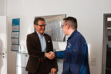 Zwei Männer die sich die Hand geben.