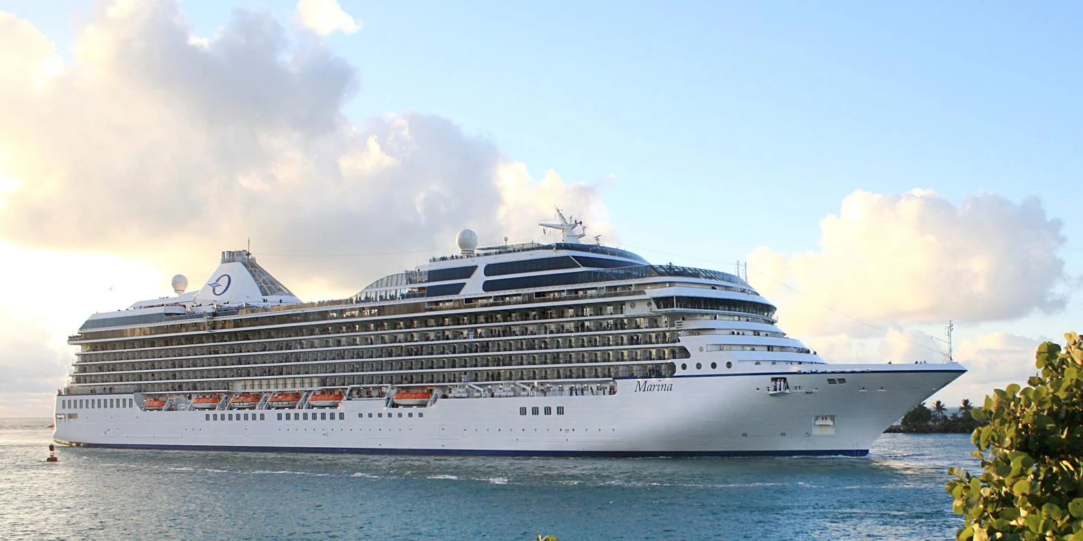 Cruise ship departing a tropical port at sunset