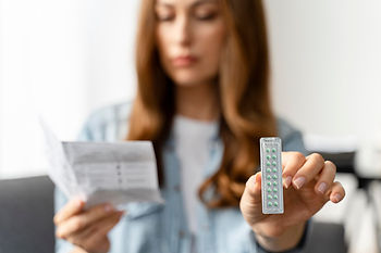 Mulher lendo a bula de medicamento