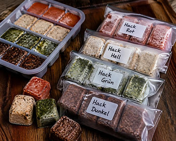 Vier eingefrorene Hackfleisch Grundsoßen als Meal Prep Würfel auf einem Holzbrett