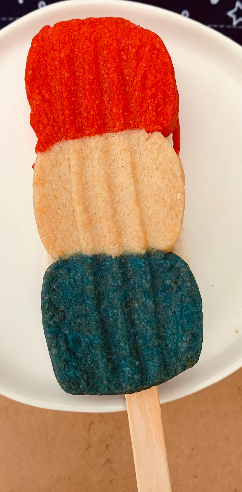 Thumbnail: red white and blue sandwich cookie make to look like a popsicle on a stick with buttercream filling