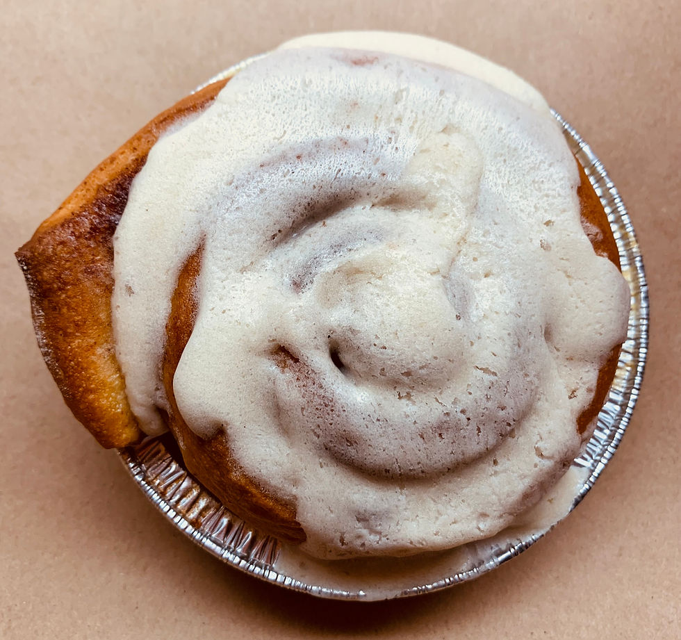 Thumbnail: View from the top of a well defined cinnamon roll smothered in gooey icing