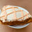 Thumbnail: a pumpkin scones with buttercream frosting in crosshatch pattern