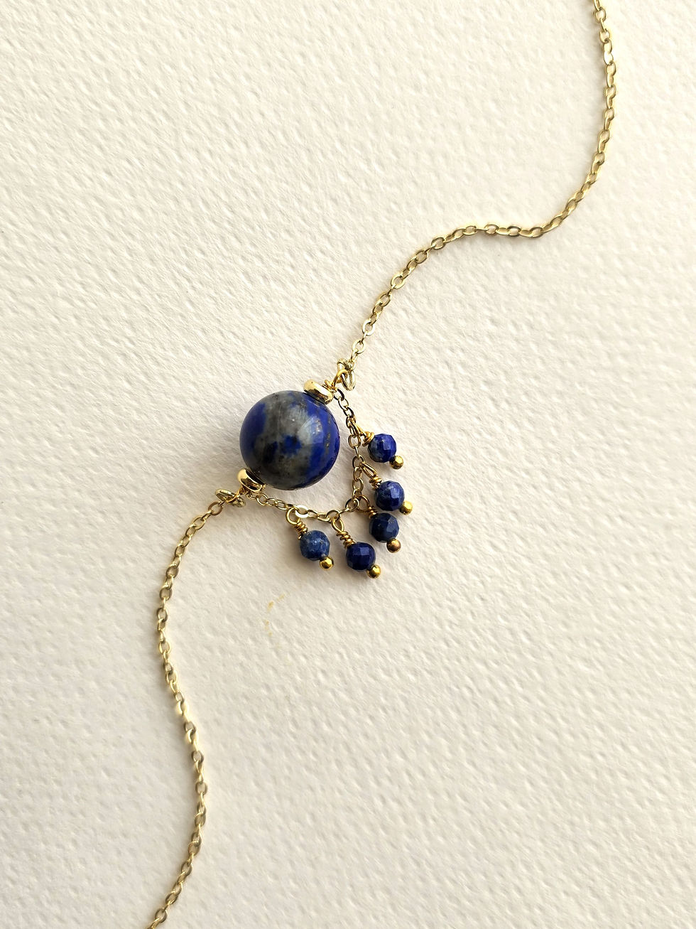 Moon’s Tribe lapis lazuli gemstone bracelet featuring deep blue beads, a statement stone and gold-tone detailing.