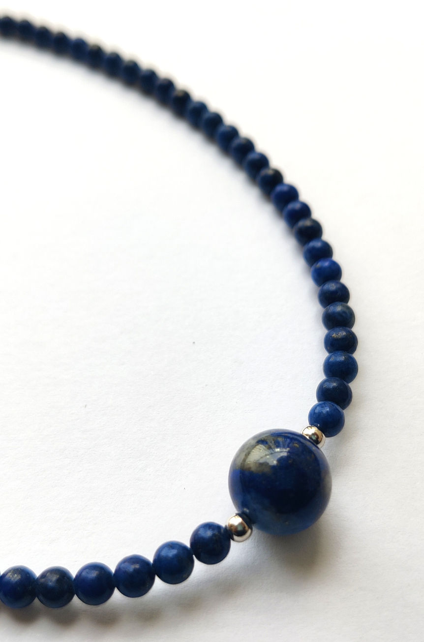 Kantha Lapis Lazuli beaded necklace with 925 silver accents on a plain background