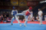 Taekwondo athletes in Olympic-style sparring match demonstrating strategy and skill