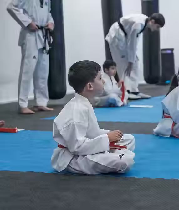 Children enjoying games and activities in martial arts uniforms during a Mozhdeh Martial Arts celebration
