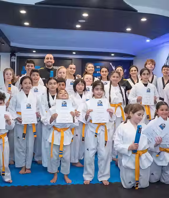 Group of young martial artists holding certificates at Mozhdeh Martial Arts, celebrating teamwork and leadership growth