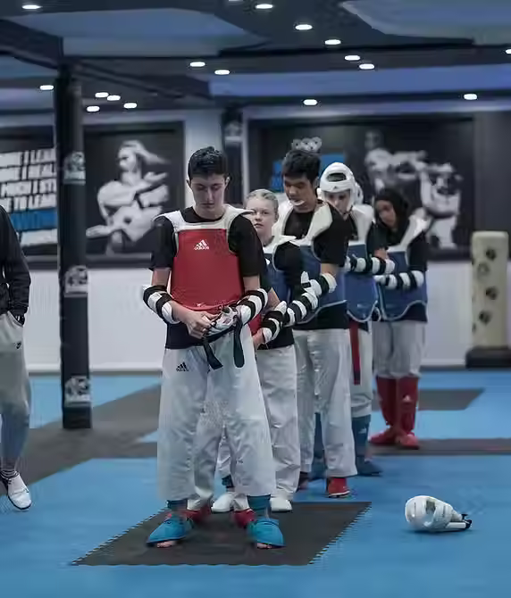 Students at Mozhdeh Martial Arts lined up for performance analysis and feedback after sparring practice