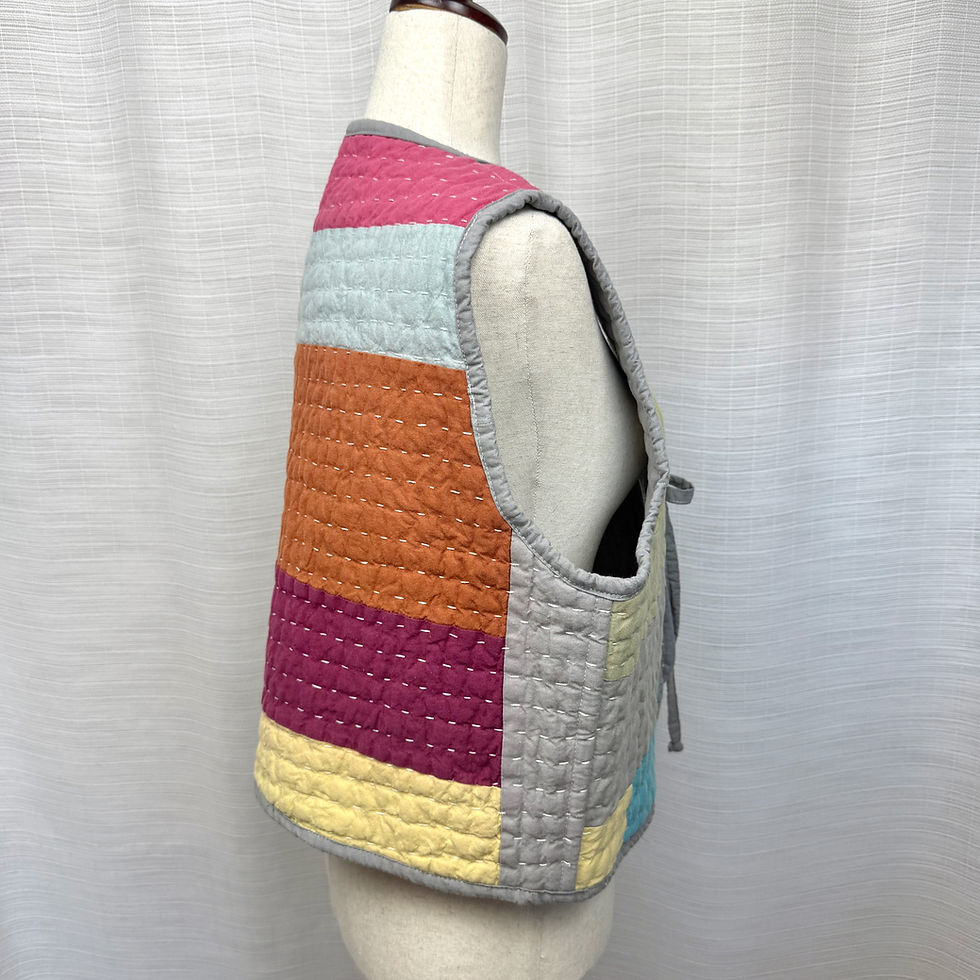 Thumbnail: Side view of reversible quilted vest showing bright patchwork colors