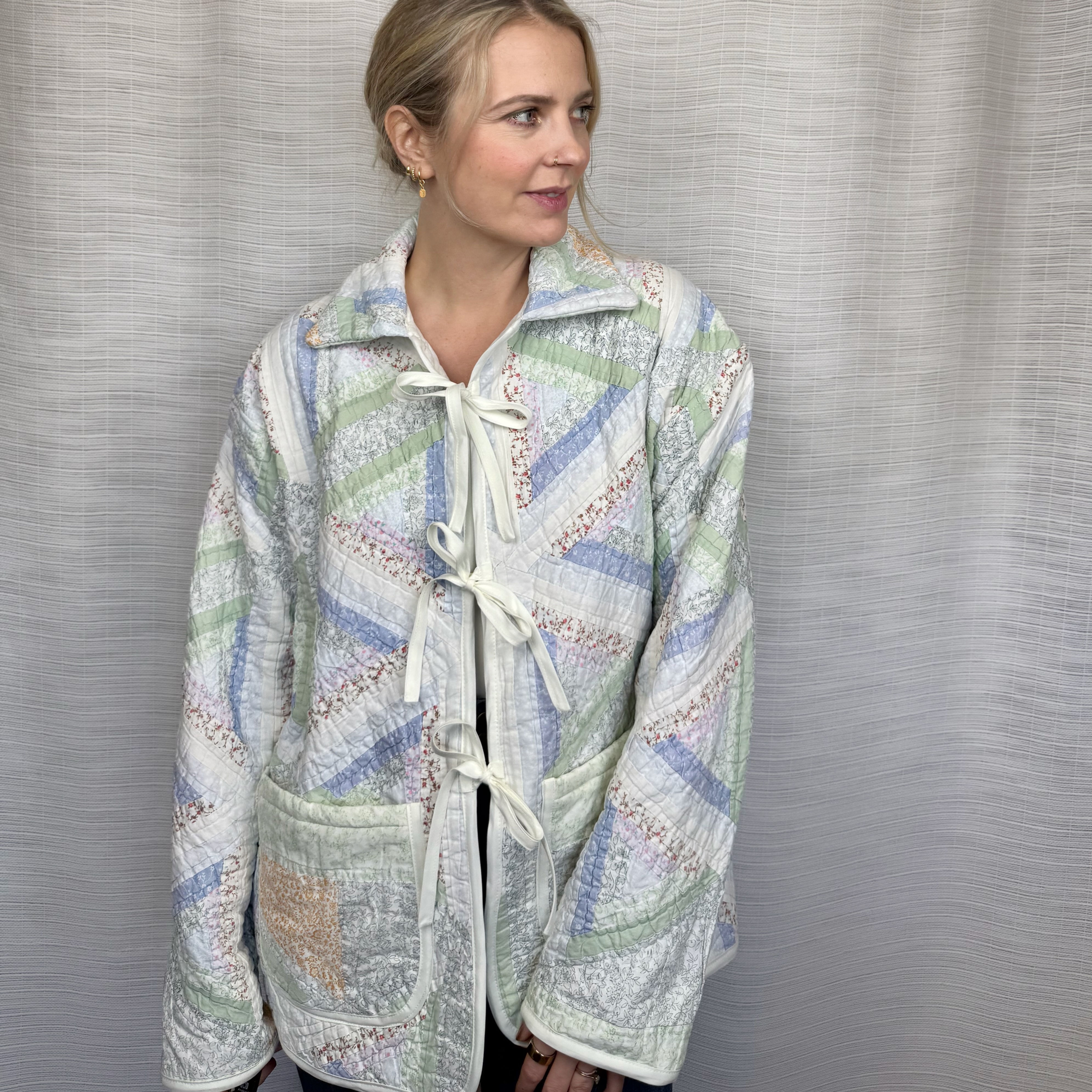 Upcycled pastel quilted jacket with tie front and pockets, front view on model (L)