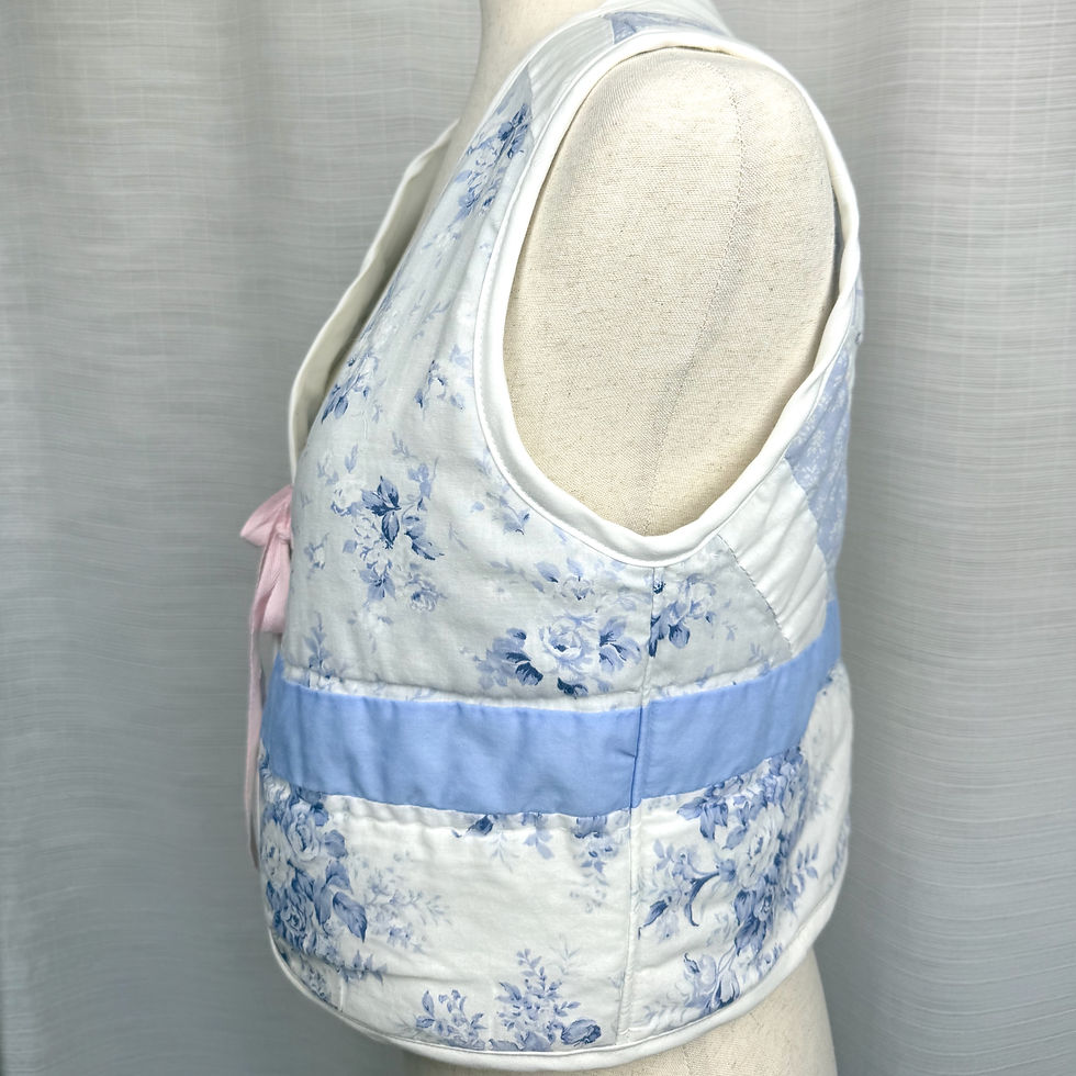 Thumbnail: Side view of blue floral patchwork quilted vest handmade from vintage quilt.