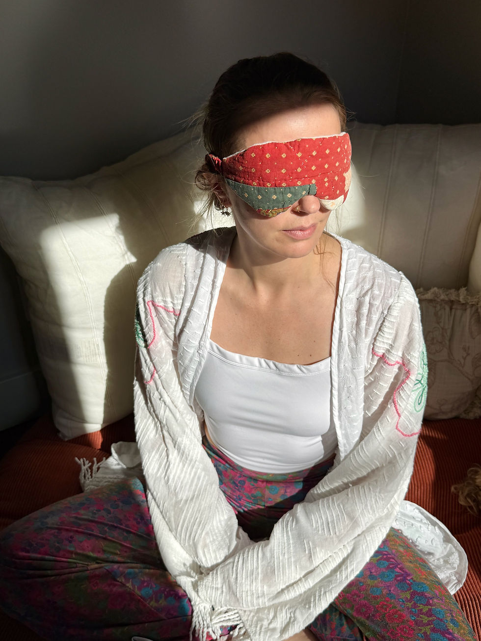 Thumbnail: Woman resting with a cushioned rust and green patchwork vintage quilt eye mask during a relaxing self-care session.