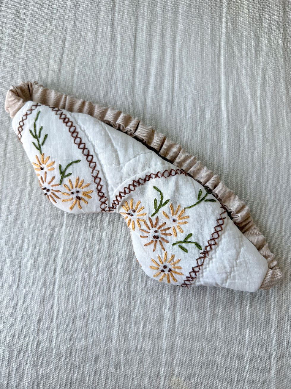 Upcycled vintage quilt eye mask for meditation featuring warm marigold floral embroidery and a taupe elastic band.