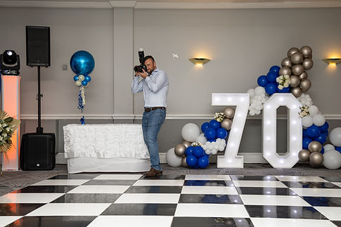 The photographer is trying to capture a beautiful scene at a birthday party