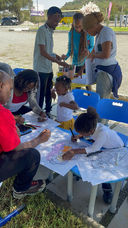 Pupils drawing outdoors alongside their parents and teachers during a school art activity at Fadhili International School