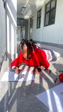 Children drawing while lying down on the corridor floor at Fadhili International School.