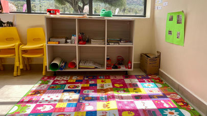 Decorated classroom desks with books, pencils, and crafts at Fadhili International School