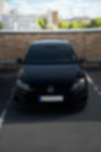 Černý vůz Volkswagen zaparkovaný zepředu.