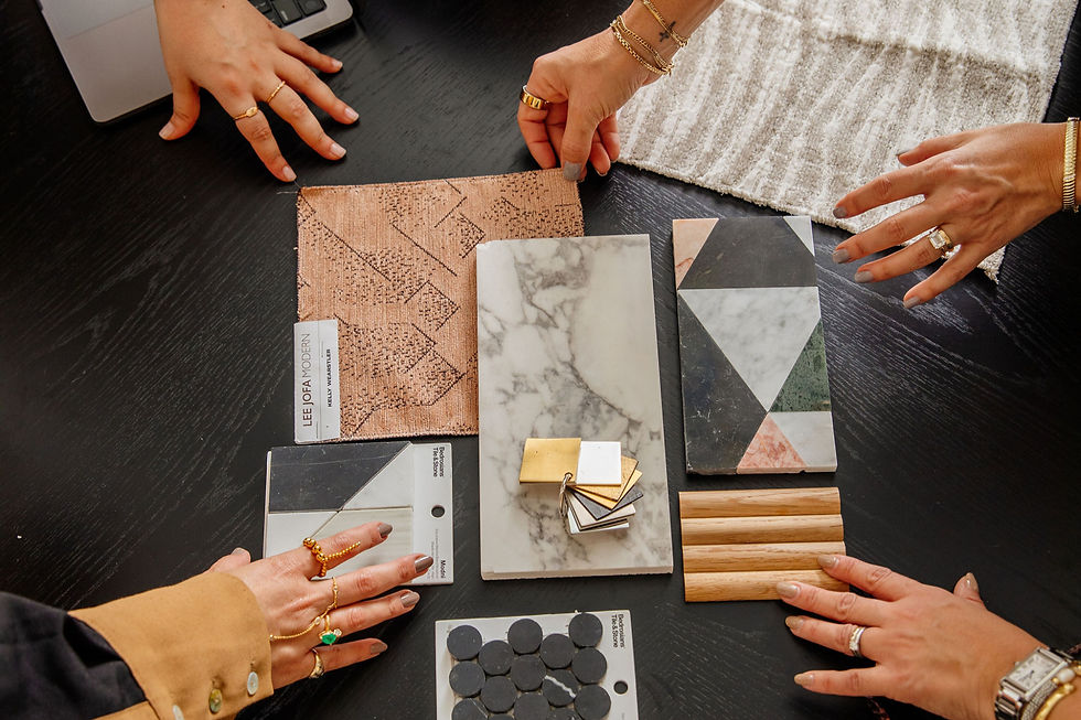 Hands with rings compare fabric, marble, wood, and tile samples on a black table, with Lee Jofa Modern and Bedrosians labels.