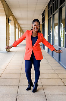 Fun personal branding photography, a lady in an orangey red blazer with arms out smiling