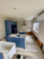 Completed kitchen renovation with navy blue lower cabinets, white upper cabinets and an island bench