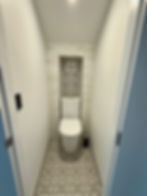 Toilet with space-saving wall niche in a small patterned-tile bathroom