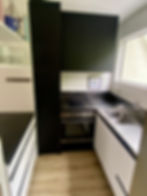 Finished modern kitchen with sleek black cabinetry and dark benchtop by Sorted Home Solutions