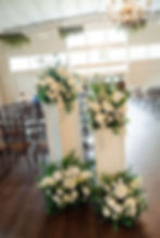 White wedding floral arrangements with greenery.