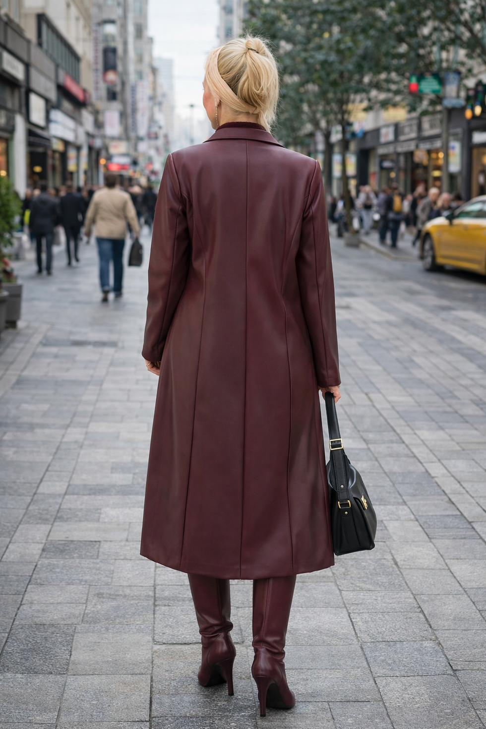 Woman in a long red coat walking down a city street
