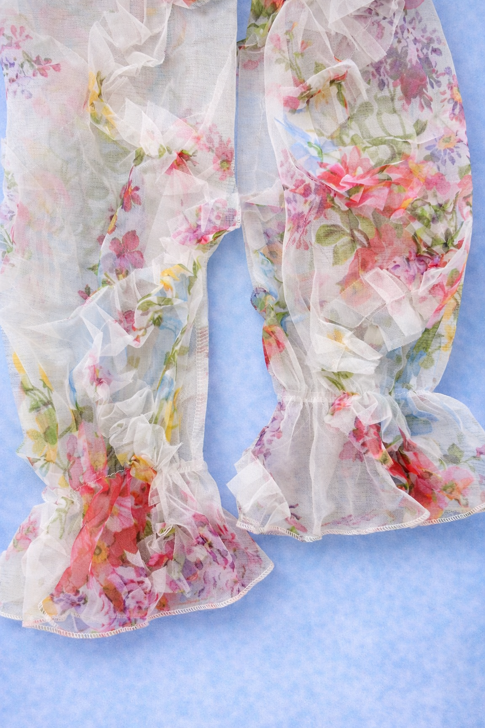 Thumbnail: Sheer white fabric with colorful floral print and ruffled cuffs