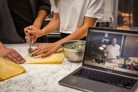 Couple making ravioli with an Italian chef on a computer screen
