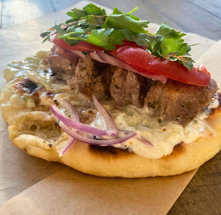 Making a Souvlaki pita with tzatziki