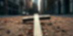 an image of a broken cross laying in the ground in the city.jpg
