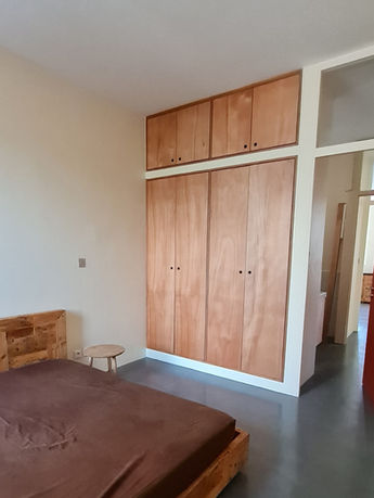 Chambre rénovée avec dressing toute hauteur en contreplaqué d’Okoumé et sol en béton ciré gris