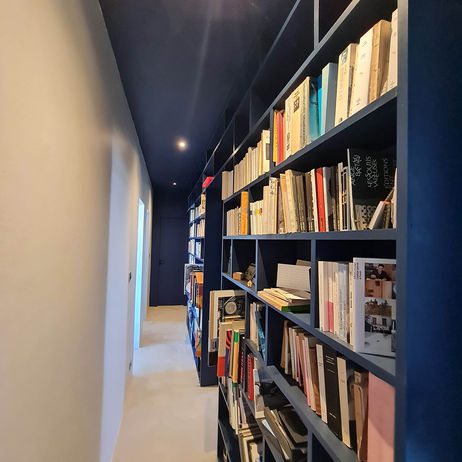 Bibliothèque intégrée avec plafond peint bleu nuit – rénovation appartement contemporain